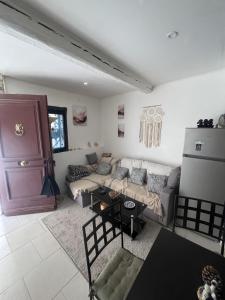 a living room with a couch and a table at Maison calme et climatisée - Proche Nîmes & Arles in Saint-Gilles