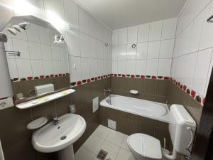 a bathroom with a sink and a tub and a toilet at Hotel Golden Beach in Eforie Nord +20 photos