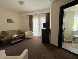 a living room with a couch and a television at Hotel Golden Beach in Eforie Nord