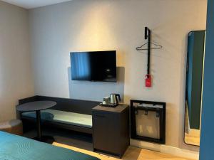 a room with a bed and a tv on the wall at Hotel SIS - Rooms in Steenbergen