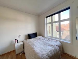 a bedroom with a bed and a large window at Apartment in the center of Bergen in Bergen