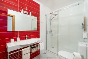 ein Badezimmer mit roten Wänden, Waschbecken und Dusche in der Unterkunft villa vista do vale in São Vicente + 58 Fotos