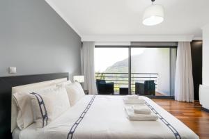 ein Schlafzimmer mit einem großen Bett mit einem großen Fenster in der Unterkunft villa vista do vale in São Vicente