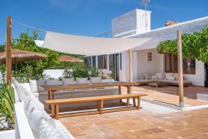 un patio con tavolo e panche in legno di Villa Bini Ezolea a Binibeca