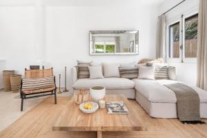 un soggiorno con un divano bianco e un tavolo di Villa Bini Ezolea a Binibeca