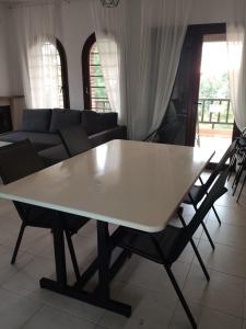 a white table in a living room with a couch at Villa Panorama in Mola Kalyva +6 photos