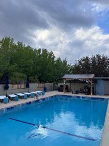 a large blue swimming pool with a gazebo at Andruss Motel in Walker