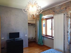 a bedroom with a chandelier and a tv and a window at Nina in Monfalcone