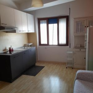 a kitchen with white cabinets and a counter top at La Casa di Raffa in Agropoli