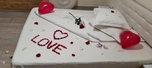 a cake with hearts on a bed with the words love at Casa SEMA in Sinaia +171 photos