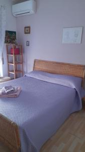 a bed with a blue blanket on top of it at La Casa di Raffa in Agropoli