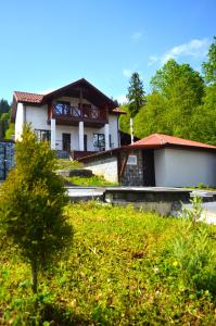 a house with a building in the background at Villagoria котедж з басейнами і джакузі in Slavske +19 photos
