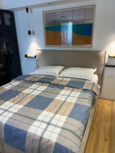 a bedroom with a bed with a blue and white blanket at רויאל שנגרילה in Eilat