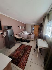 ein Schlafzimmer mit Bett und eine Küche mit Kühlschrank in der Unterkunft Sweetpea in Boksburg