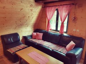 a living room with a leather couch and a table at Planinska kuća BRDO in Zlobin