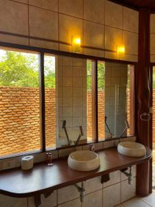 La salle de bains est pourvue de 3 lavabos et d'un grand miroir. dans l'établissement Pousada Fazenda São Bento, à Alto Paraíso de Goiás