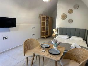 a room with a bed and a table with chairs at Arch Residence, studio 3, Vroulidia in Katarráktis