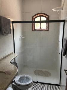 a bathroom with a shower with a sink and a toilet at Refúgio wbenthé in Paty do Alferes