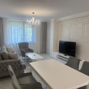 ein Wohnzimmer mit Sofa und Fernseher in der Unterkunft GRAND RESORT APARTAMENTS DARIS -free parking in Kasanlak