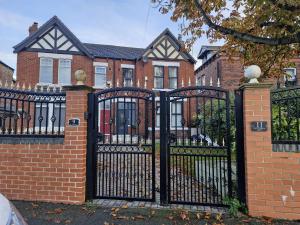 a black iron gate in front of a brick house at Grange House Budget Rooms in Leeds