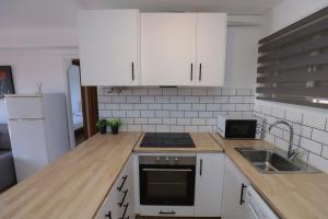 Una cocina con gabinetes blancos y un fregadero. en DIFFERENTFLATS Dms, en La Pineda