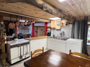 a kitchen with white cabinets and a wooden table at L'abri de rioumaou in Saligos +19 photos