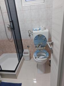 a bathroom with a shower and a toilet with a blue seat at Apartments Vink in Vir +29 photos