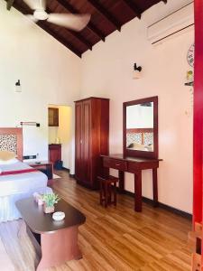 a bedroom with a bed and a desk and a mirror at Olu Vila Private Cabana in Mabodale