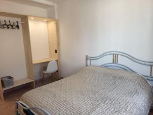 a bedroom with a bed and a cabinet and a chair at Julian Sardigliano in Cassano Spinola