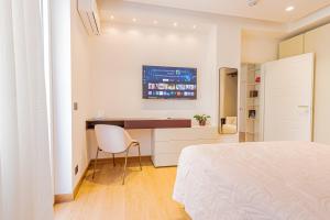 a white bedroom with a desk and a bed at Colour Suite in Naples