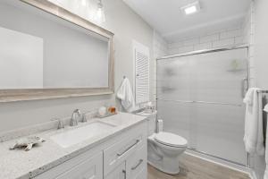 a white bathroom with a sink and a toilet at Beach and Golf Adventures 3 Bedroom Sleeps 6 in Pawleys Island +18 photos