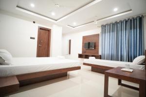 Royal Majestic Lodge في غاواهاتي: غرفة فندقية بسريرين وتلفزيون