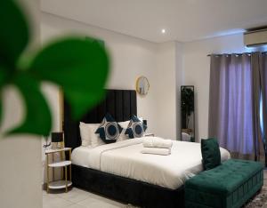 a bedroom with a large bed and a green chair at RoyalRest at Signature CPG in Accra +12 photos
