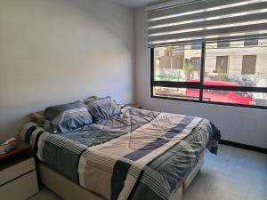 a bedroom with a bed and a window at Departamento a estrenar excelente ubicacion Achumani in La Paz