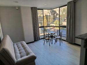 a living room with a couch and a table and chairs at Departamento a estrenar excelente ubicacion Achumani in La Paz