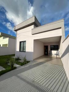 锡诺普Casa completa e aconchegante com fácil acesso ao aeroporto的前面有两把椅子的白色房子