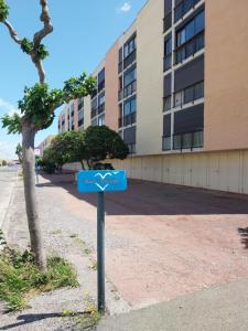 un panneau bleu devant un bâtiment dans l'établissement Appartement T2 lumineux à 200m de la plage, tout équipé, à Port-la-Nouvelle