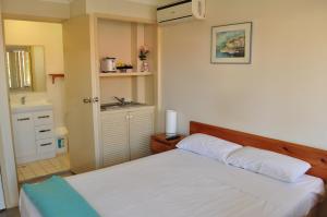 a bedroom with a white bed and a sink at Isla House PA in Brisbane