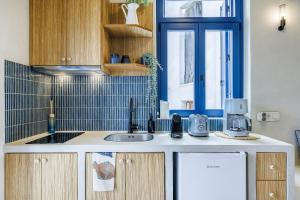 a kitchen with a sink and a refrigerator at Campanile Seaview Serenity in Skopelos Town