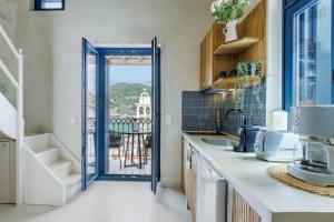 a kitchen with a door leading to a balcony at Campanile Seaview Serenity in Skopelos Town