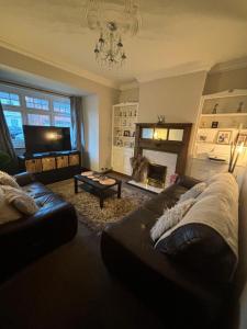 Una sala de estar con un sofá y una chimenea. en Birkdale Golf Open Holiday Home, en Southport