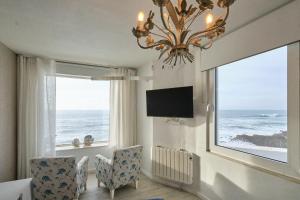 a dining room with a chandelier and a large window at Casal Santa Virginia in Sintra
