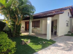 une maison avec un palmier devant dans l'établissement Casa OLiveira, à Cachoeira Paulista
