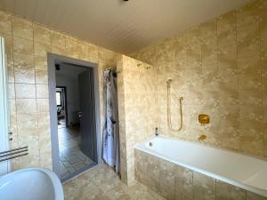 a bathroom with a bath tub and a shower at Ferienhaus mit Panoramablick in Ohlsdorf +19 photos
