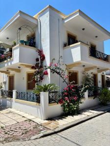 a white building with flowers in front of it at Eleni Seaside Retreat in Kos Town
