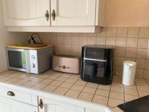 a kitchen with a coffee maker and a microwave at Une pause à Dompierre in Dompierre-en-Morvan