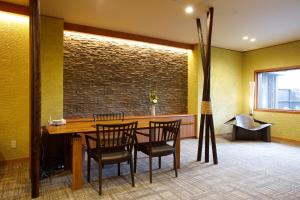 a dining room with a wooden table and chairs at Yunokawa Onsen Emi Hakodateya in Hakodate
