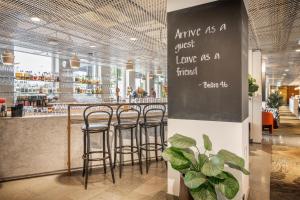 a bar with stools in a restaurant with a sign at Best Western Plus Sthlm Bromma in Stockholm +37 photos
