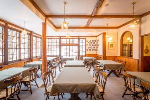 a dining room with tables and chairs and windows at Hakuba Skala Inn in Hakuba