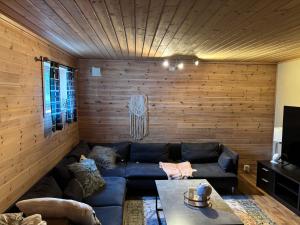a living room with a blue couch and wooden walls at Eikestua in Sokndal